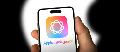 Bildbeschreibung: Das Bild zeigt eine Hand, die ein Smartphone hält, auf dessen Bildschirm ein farbenfrohes Logo mit der Aufschrift "Apple Intelligence" angezeigt wird.