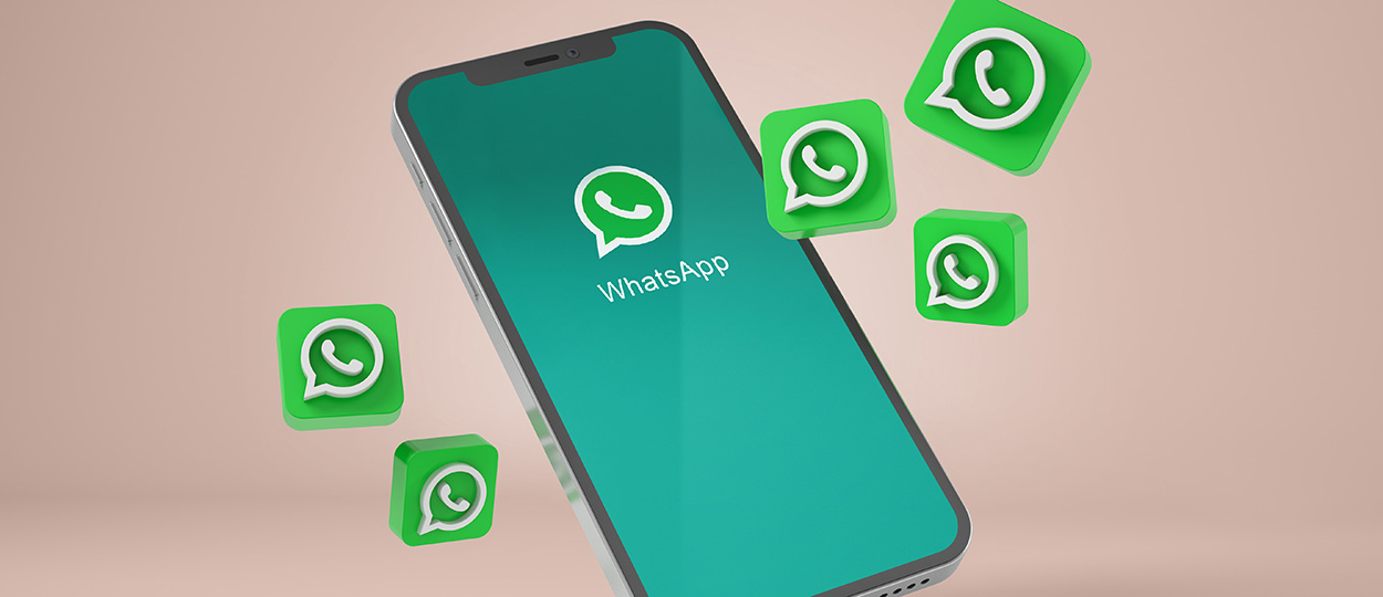 Bildbeschreibung: Das Bild zeigt ein Smartphone mit dem geöffneten WhatsApp-Logo auf dem Bildschirm, umgeben von schwebenden, grünen WhatsApp-Symbolen auf einem beigen Hintergrund.